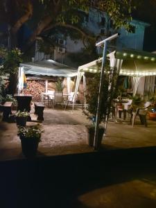 a patio at night with a table and chairs at Вила Радеви in Obzor