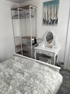 1 dormitorio con cama, tocador y espejo en Sea Shells en Torquay
