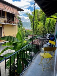 einen Balkon mit einem gelben Stuhl und einer Pflanze in der Unterkunft Ca’ 2810 Vacation Rental Baveno in Baveno