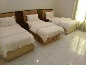 a room with two beds with white sheets at روائع الأحلام للاجنحة الفندقية in Jeddah