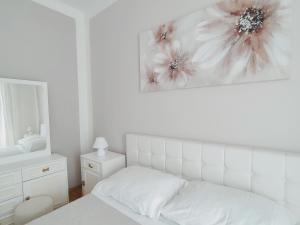 een witte slaapkamer met een bed en een schilderij aan de muur bij Fami Superior One Bedroom Apartment in Rijeka