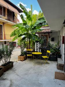 eine Terrasse mit einem Tisch, Stühlen und einer Palme in der Unterkunft Ca’ 2810 Vacation Rental Baveno in Baveno