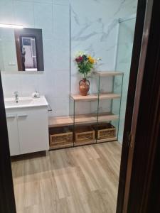 een badkamer met een wastafel en een vaas met bloemen bij Allotjament dels Ports in La Senia