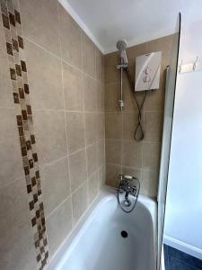 a bath tub in a bathroom with a shower at Perfect Home From Home In Stoke on Trent in Etruria