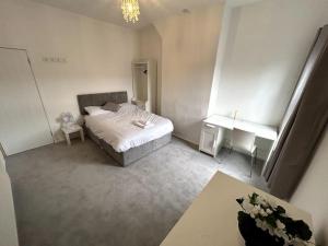 Schlafzimmer mit einem Bett, einem Schreibtisch und einem Fenster in der Unterkunft Perfect Home From Home In Stoke on Trent in Etruria