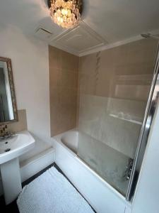 a bathroom with a shower and a sink and a tub at Perfect Home From Home In Stoke on Trent in Etruria