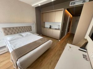 a bedroom with a large bed and a kitchen at Barakah Apartmets Batumi in Batumi
