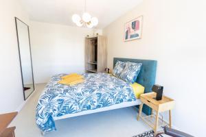 een slaapkamer met een blauw en wit bed en een tafel bij Le Royal 4* – Grand Confort Salle de Sport privée in Vandoeuvre-lès-Nancy