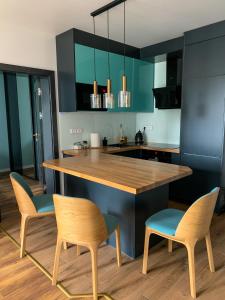 a kitchen with two chairs and a wooden counter top at Belzacka City Apartment in Piotrków Trybunalski