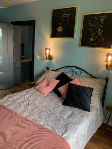 een slaapkamer met een bed met roze en zwarte kussens bij Belzacka City Apartment in Piotrków Trybunalski