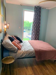 a bedroom with a bed with a window and a table at Belzacka City Apartment in Piotrków Trybunalski