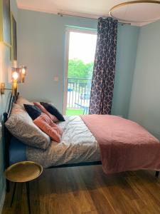 um quarto com uma cama, uma janela e uma mesa em Belzacka City Apartment em Piotrków Trybunalski