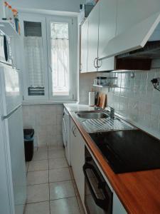een keuken met een wastafel en een witte koelkast bij Fami Superior One Bedroom Apartment in Rijeka