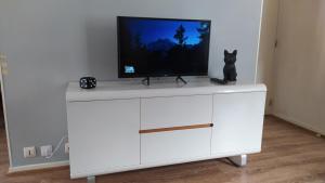 ein weißes Entertainment-Center mit einem TV darüber in der Unterkunft Appartement Fx 1 in Saint Die