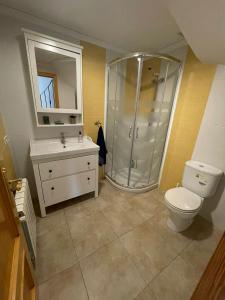 a bathroom with a shower and a toilet and a sink at Chalet en playa de Almardá in Almarda