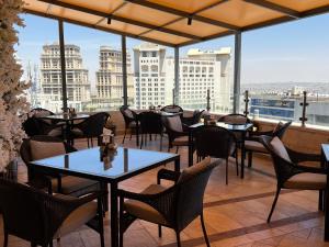 a restaurant with tables and chairs and a view of the city at Retaj Hotel in Amman
