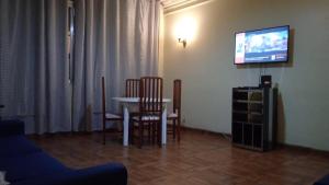 uma sala de estar com uma mesa e cadeiras e uma televisão em Apartamento de Copacabana ( Posto 5 ) no Rio de Janeiro