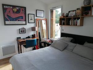 Schlafzimmer mit einem Bett, einem Schreibtisch und einem Fenster in der Unterkunft Attique vue mer et campagne, la plage à pied in Saint-Jean-de-Luz