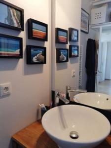 ein Badezimmer mit zwei Waschbecken und Bildern an der Wand in der Unterkunft Attique vue mer et campagne, la plage à pied in Saint-Jean-de-Luz