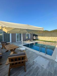 une terrasse avec un parasol et une piscine dans l'établissement Talia Villalari, à Fethiye