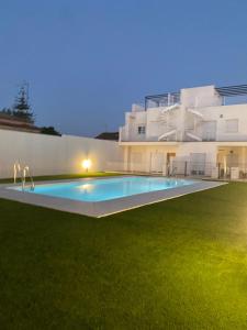 a large swimming pool in front of a building at Apartamento Turístico Damajuana Parking Free in Espartinas