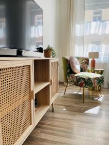 ein Wohnzimmer mit einem TV und einem Stuhl in der Unterkunft Apartment Boho Living in Bautzen