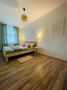 Un dormitorio con una cama y suelo de madera. en Apartment Boho Living, en Bautzen
