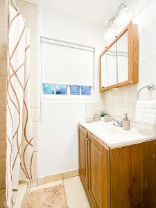 uma casa de banho com um lavatório e uma janela em Charming 1 BR Poolside Retreat - Lou2-Bur em Burbank