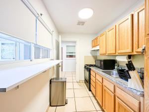 a kitchen with wooden cabinets and a counter top at Charming 1 BR Poolside Retreat - Lou2-Bur in Burbank