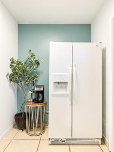 einen weißen Kühlschrank in einem Zimmer mit einem Tisch in der Unterkunft Charming 1 BR Poolside Retreat - Lou2-Bur in Burbank