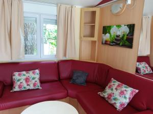 czerwona kanapa z poduszkami w salonie w obiekcie En Saubis 
