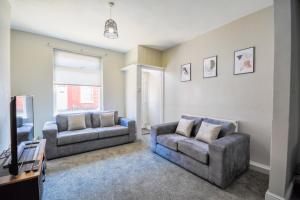a living room with two couches and a tv at Stay with Alexandra in Liverpool