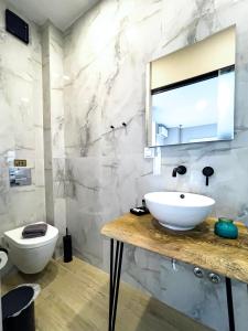La salle de bains est pourvue d'un lavabo et de toilettes. dans l'établissement ATHONITE all seasons luxury suites, à Ierissos