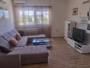 a living room with a couch and a tv at Rosa in Solin
