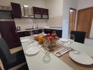 a kitchen table with a bowl of fruit and wine glasses at Rosa in Solin