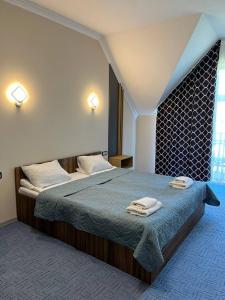 sypialnia z 2 łóżkami i ręcznikami w obiekcie RIVER SIDE w mieście Polyana (Polana)