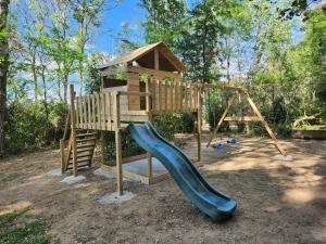 um parque infantil com escorrega e uma casa de brincar em Domaine à l'Aise em Plaissan