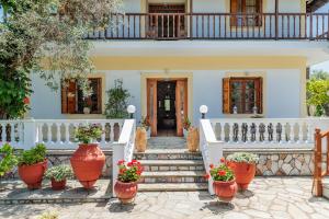 una casa bianca con piante in vaso sulle scale di Panagou Studios a Skopelos Town