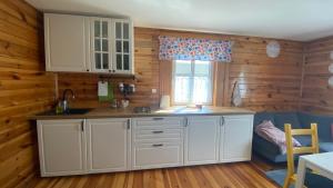 a kitchen with white cabinets and a window at Siedlisko Rozalin in Rozalin