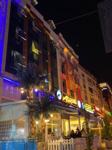 Ein Gebäude mit Leuten, die nachts draußen sitzen. in der Unterkunft TRABZON Asel Suite Otel in Trabzon