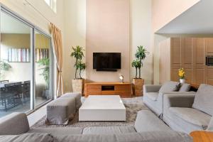 sala de estar con 2 sofás y TV en 3149 Magic Village 8 guests 4 suites 8min Disney, en Orlando