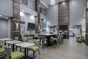 Hampton Inn & Suites By Hilton-Corpus Christi Portland,Tx في بورتلاند: مطعم فيه طاولات وكراسي في الغرفة