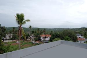 uma vista a partir da varanda de uma casa com uma palmeira em V.A TOURIST RESIDENCY em Taliparamba