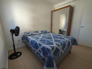 a bedroom with a bed with a blue and white comforter at Aruana Azul 502 - Apto com AR, PISCINA, Varanda Integrada - Aluguel por Temporada in Aracaju +19 photos
