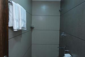uma casa de banho com chuveiro, WC e toalhas em V.A TOURIST RESIDENCY em Taliparamba