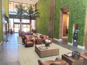 een lobby met banken, stoelen en planten bij 3053 Magic Village 3 suites jacuzzi BBQ 6min Disney in Orlando