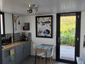 a kitchen with a table and a table and a window at Gîte PAPYRUS in Sainte-Eulalie-en-Born