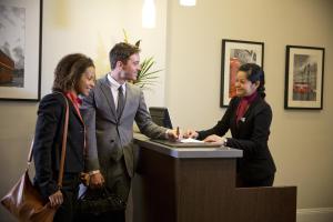 a group of three people standing around a desk at Thistle London Bloomsbury Park in London