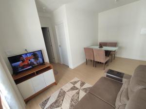 a living room with a couch and a tv on a cabinet at Aruana Azul 502 in Aracaju