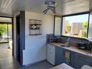 a kitchen with a sink and two windows at Gîte PAPYRUS in Sainte-Eulalie-en-Born +10 photos